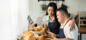 Young man with developmental disaability helping his mom make dinner